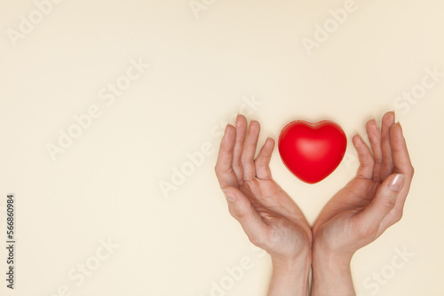 Fototapeta Naklejka Na Ścianę i Meble -  Health, medicine and charity concept - close up of female hands with small red heart.