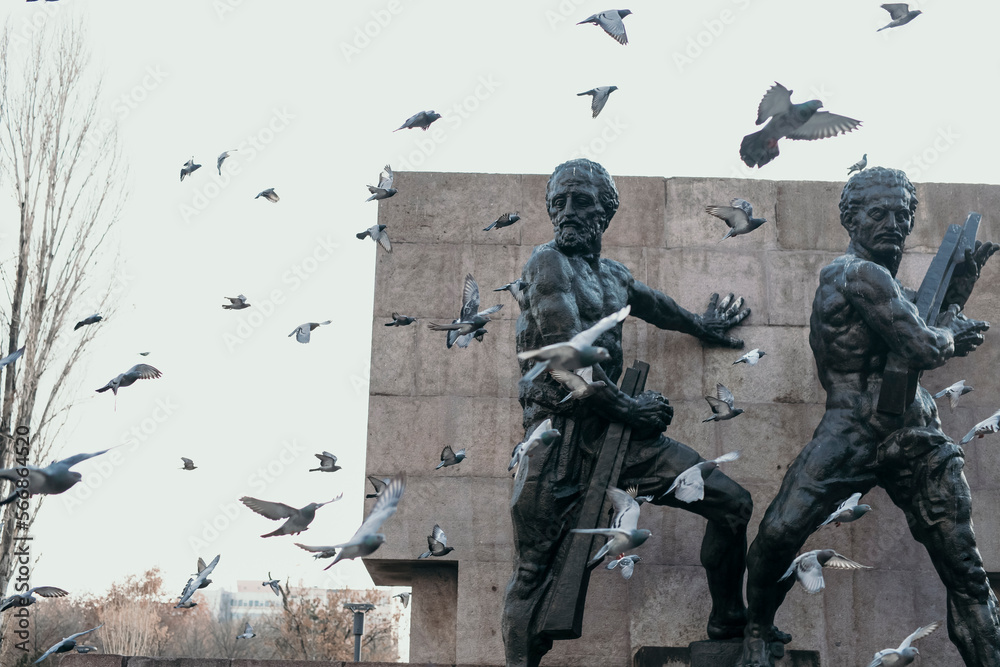 ikili adam heykeli ve uçuşan güvercinler