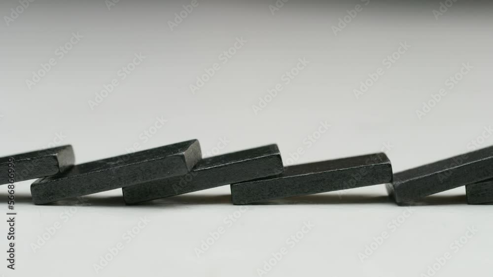 row of black dominoes in a white studio row of black dominoes in a white studio