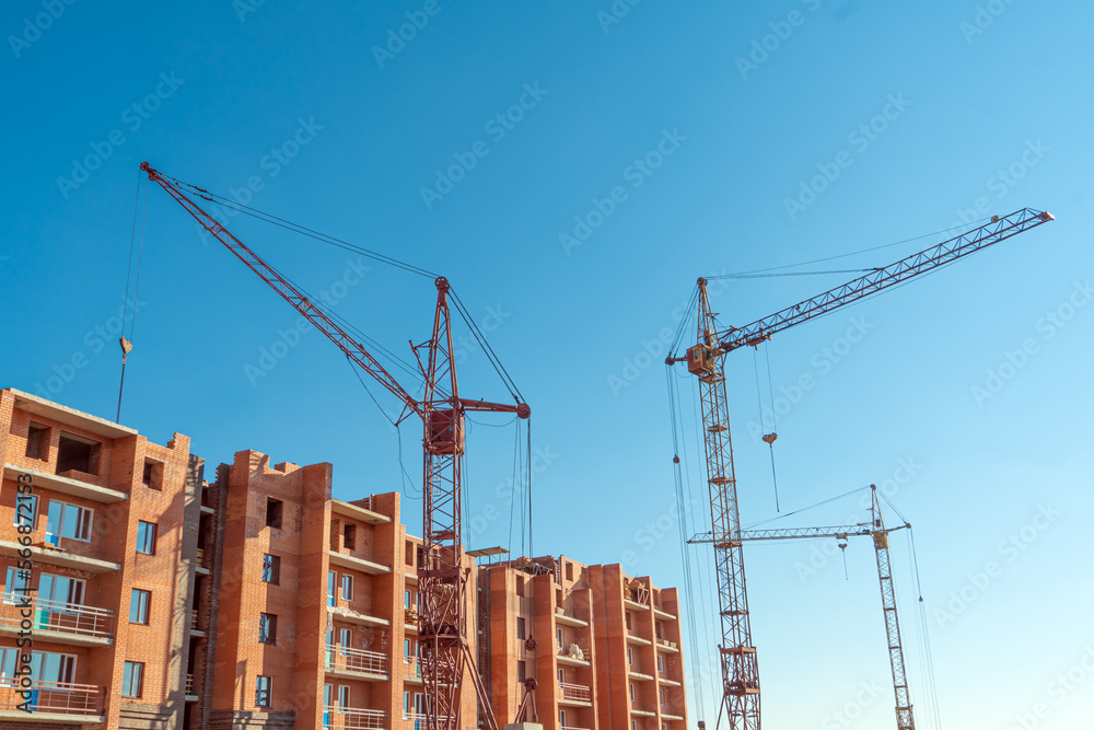 Construction site with a crane.Long-term construction.A new building under construction,bottom-up view.Unfinished skyscraper,frozen construction.Unfinished construction of a multi-storey residential