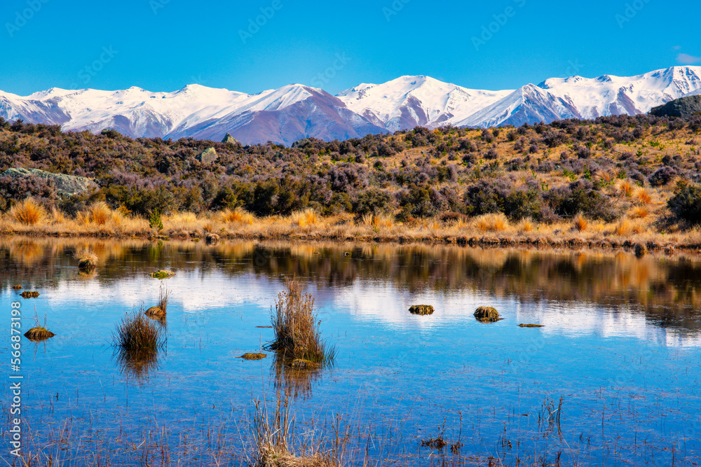 A small lagoon just off the highway on the way to the Aoraki Mount Cook National Park with the southern alps peaks reflected on the water surface