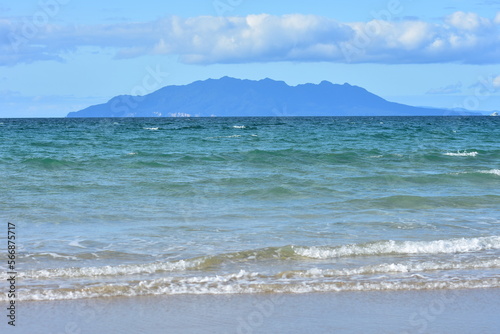 Little Barrier Island behind oceanic sandy beach with mild surf. Location: Tawharanui Peninsula New Zealand photo