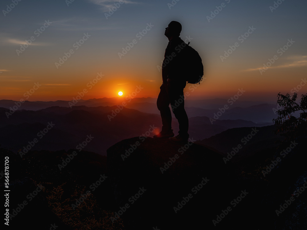 Young Man standing alone in forest outdoor with sunset nature on background Travel Lifestyle and survival concept.