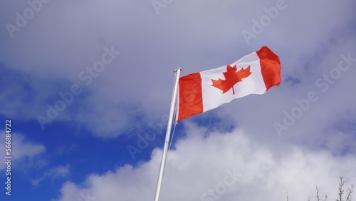 Canadian Flag on pole cloudy blue sky