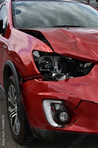 A car showing auto panel and headlight damage for repair from a front end crash.