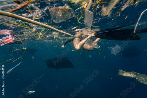 freediver swimming with plastic trash © Stepan