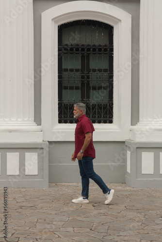 mature man walking in front of colonial classical architecture building © FotoGarageAG