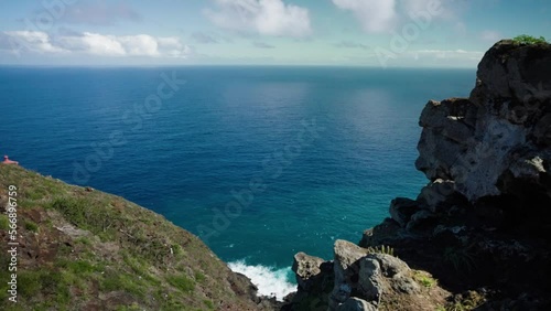 Hawaiian cliff Timelapse overlooking Pacific Ocean on sunny day with clouds. photo