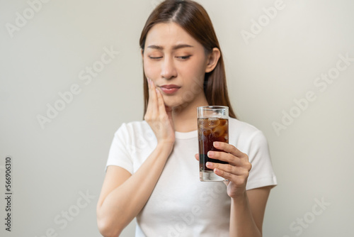 Health asian young woman touching her mouth, expression, suffering from toothache, decay or sensitivity cavity molar tooth or inflammation drink cold, sparkling water at home.Sensitive teeth people.