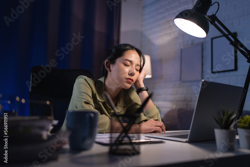 Tired asian young businesswoman is working overtime and she has lot of jobs and problem feeling stress and headache.