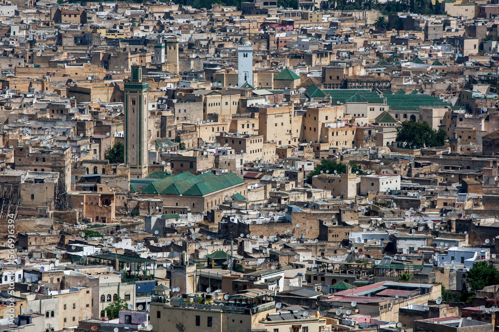 The green striped minaret of R'cif Mosque stands tall above the old city (medina) of Fez in Morocco.