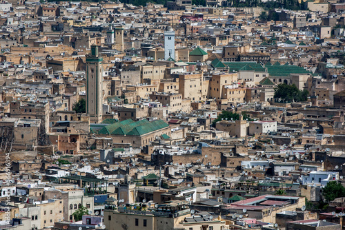 The green striped minaret of R'cif Mosque stands tall above the old city (medina) of Fez in Morocco.