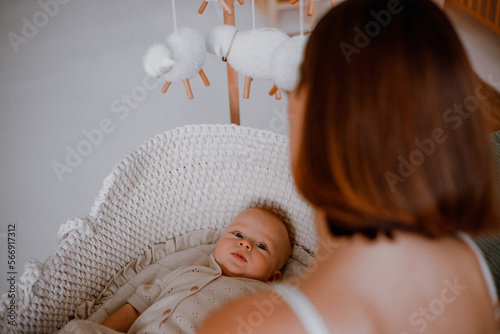 Cute newborn baby with pacifier and toy bunny lying in cradle at home, top view