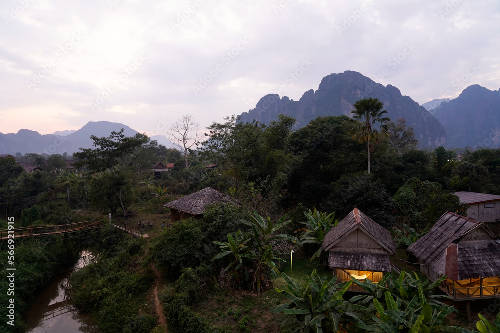 Wooden bungalows, lush foliage and a small river, Vang Vieng, Laos 