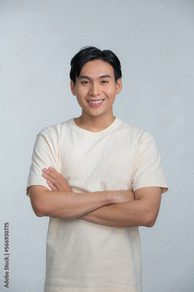 Obraz premium Portrait of a happy young man posing with arms crossed on a white background
