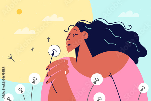 Smiling girl blow dandelion during summertime 