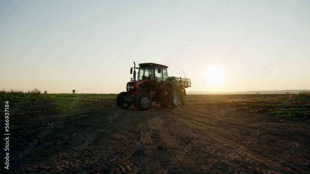 Fototapeta premium preparation process of spraying with chemicals and pesticides fields with potatoes. Growing potatoes in fields and cultivating vegetables. tractor pulls barrel with irrigation system behind it.
