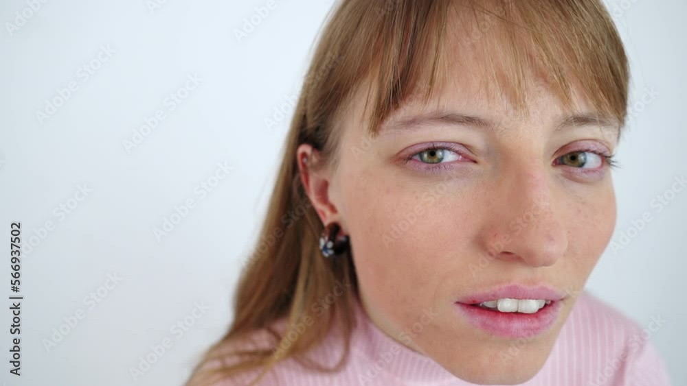 A portrait of a closeup face of a woman who looks into a camera with her eyes wide open and her eyebrows slightly raised. Curiosity concept. Disbelief. Slow motion isolated close up shot A portrait of a closeup face of a woman who looks into a camera with her eyes wide open and her eyebrows slightly raised. Curiosity concept. Disbelief. Slow motion isolated close up shot