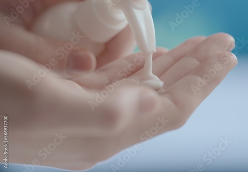 CU Close up view of young Caucasian female squeezing cream from a white tube onto her hand