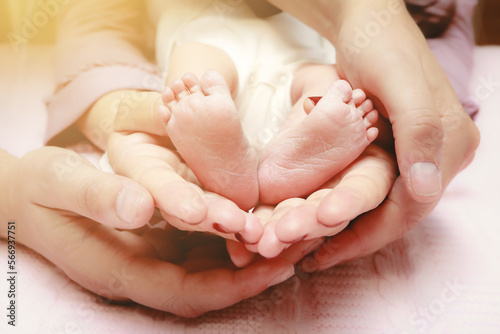 Baby feet in mother and father's hands. My parents and their child. Happy Family concept. Beautiful conceptual image of parenthood