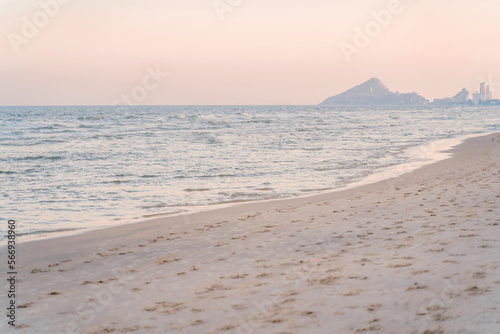 View from the beach to the mountain and Khao Takiab Temple in Hua Hin. Empty sea in dawn colors background.