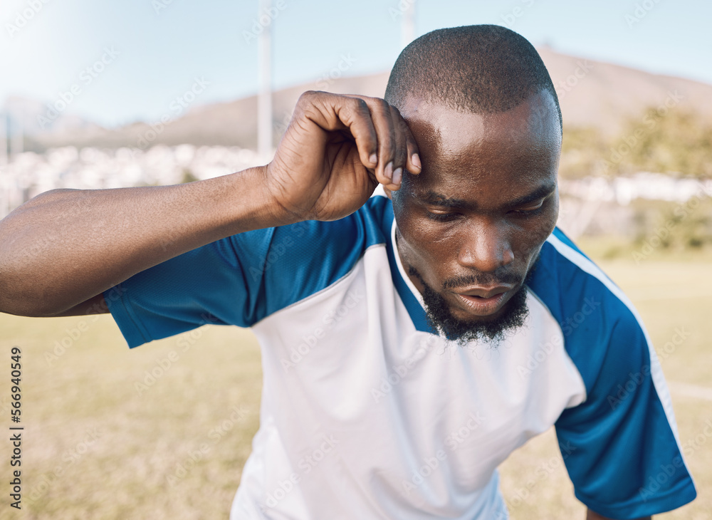 Naklejka premium Black man is tired, face and football player on outdoor field, playing game or soccer training with energy and exhausted athlete. Team sport, sweating and fitness, challenge and fatigue with workout