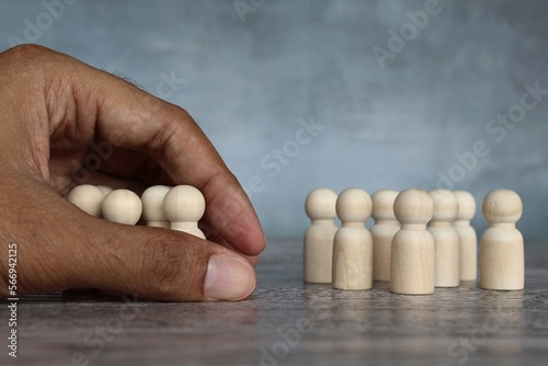 Canvas Print Hand separate group of wooden dolls