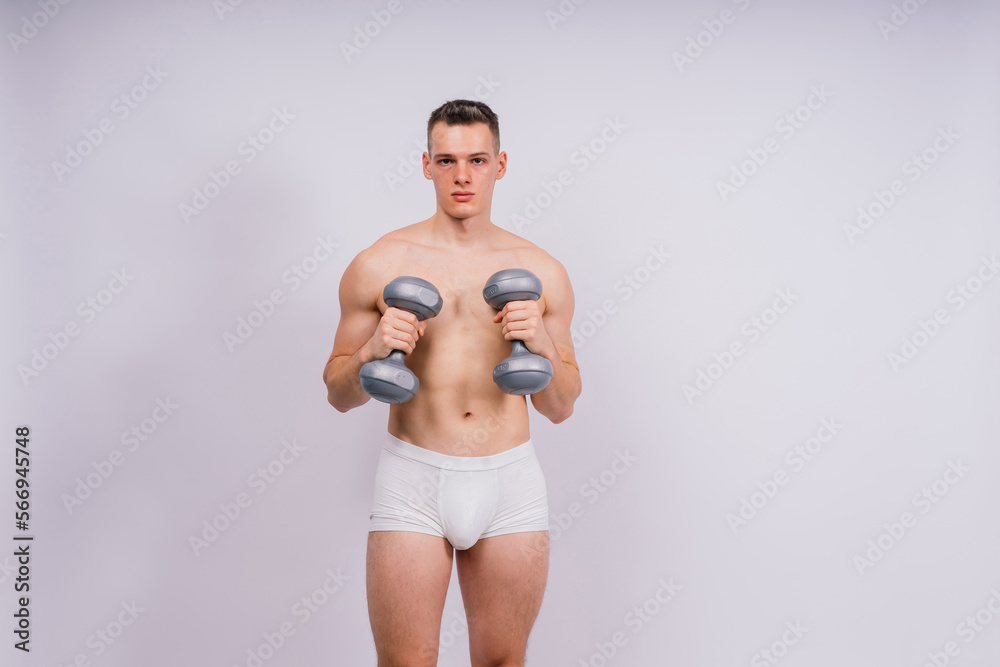 Shirtless bodybuilder holding dumbell and showing his muscular arms.