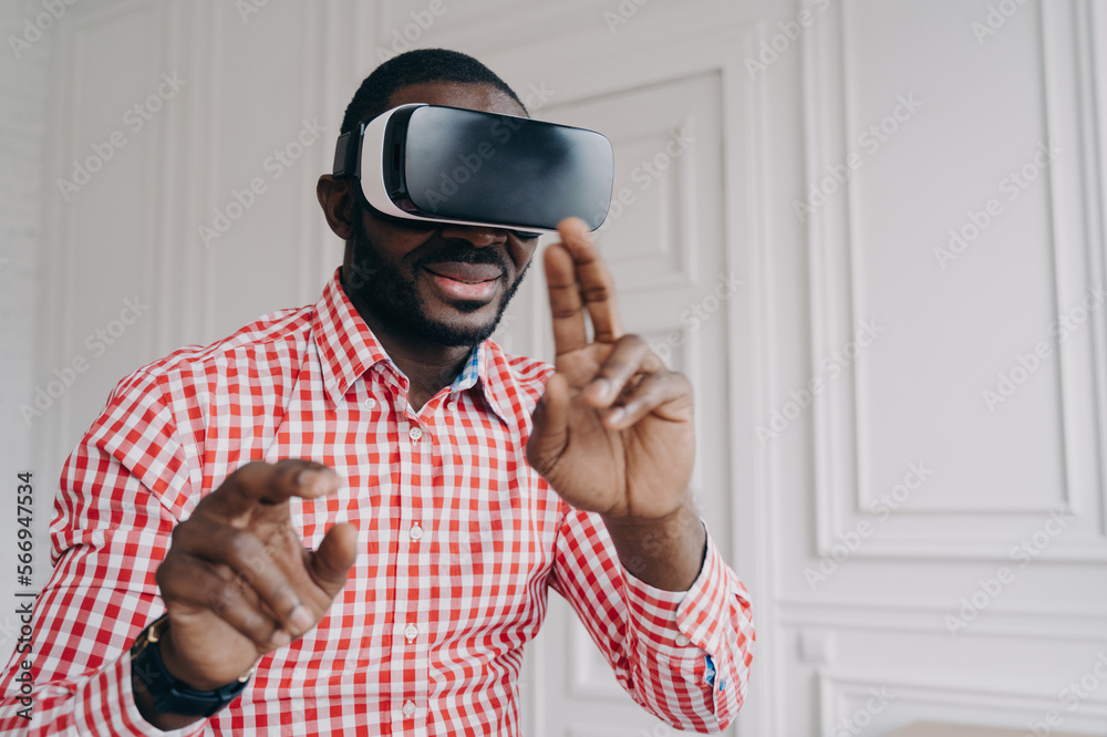Young african man wearing VR glasses enjoying gaming experience at home Young african man wearing VR glasses enjoying gaming experience at home