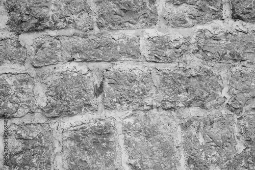 Gray vintage stonewall, close-up. Natural stone wall background for a poster, calendar, screensaver, wallpaper, postcard, banner, cover, post, website. Toned high quality photo