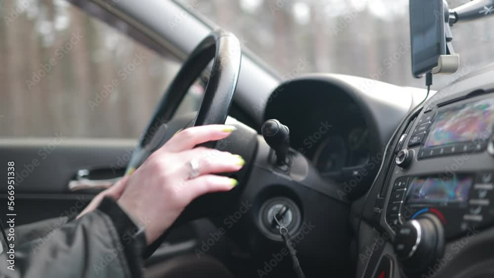 female hand turns on the radio in the car, beautiful fingers