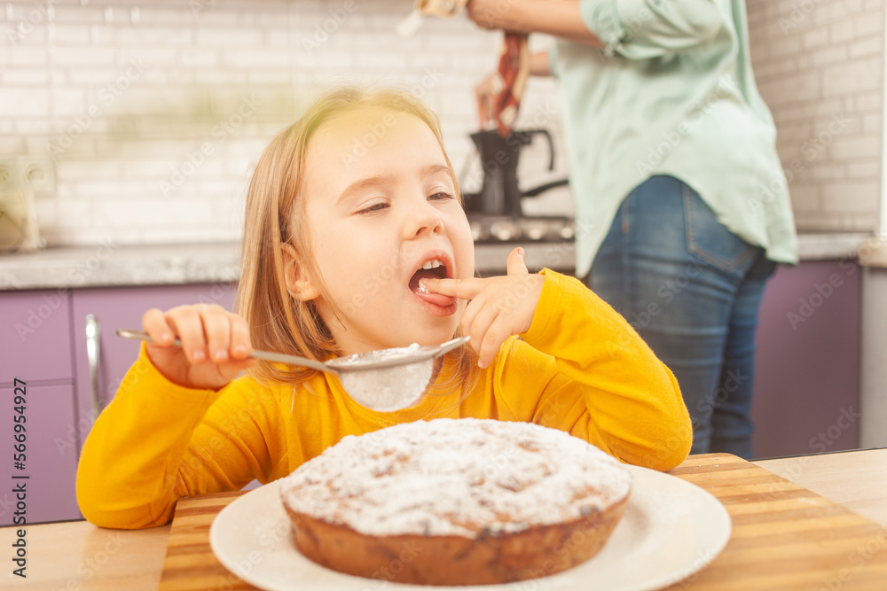 Portrait of little girl of three years old, kitchen, pie, dabbling, funny. funny, licks a finger Portrait of little girl of three years old, kitchen, pie, dabbling, funny. funny, licks a finger
