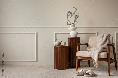 Interior design of cozy living room interior with copy space, mock up poster frame, beige vase with dried flowers, wooden bench, beige wall with stucco and personal accessories. Home decor. Template.