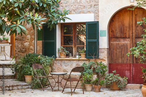 Traditional stone patio facade decorated with plants in Mallorca, Spain © h368k742