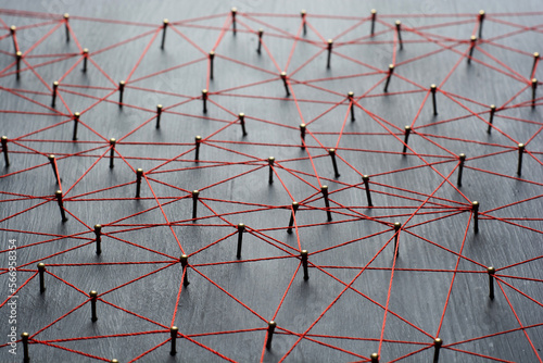 Background with selective focus. Abstract concept idea of network, social media, internet, teamwork, communication. Thumbtacks linked together by red thread. Isolated. Entities connected