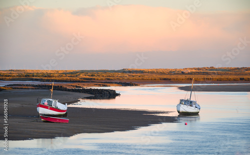 Stampa su tela Fishing boats at low tide  on the sea creek at Burnham Overy Staithe, Norfolk at