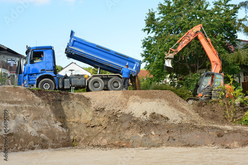 Abladen von Recycling-Schotter vom LKW als Grundlage für das Betonieren der Bodenplatte in der Baugrube eines Einfamilienhauses photo