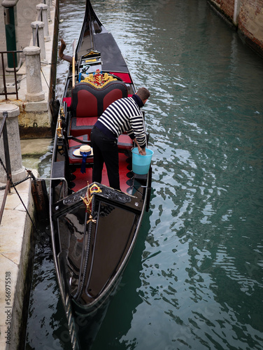 gondolier cleaning and preparing the gondola at Venice Italy