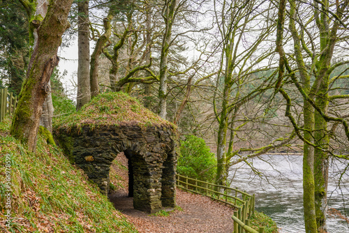 an ancient stone building on the edge of a riverbank
