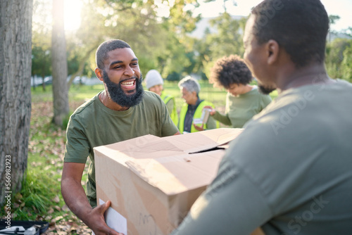 Community service, black man and giving box in park of donation, volunteering or social responsibility. Happy guy, NGO workers and helping with package outdoor of charity, support or society outreach