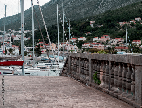 motor yachts and sailing boats view in Komolac Dubrovnik ACI Marina harbour, village , Church of Holy Spirit and maountains on background photo