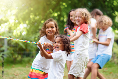 Kids play tug of war. Children pull rope.