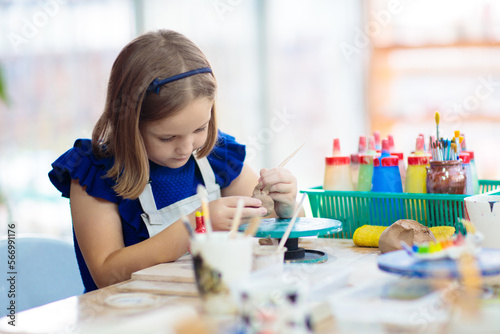 Child at pottery wheel. Kids arts and crafts class