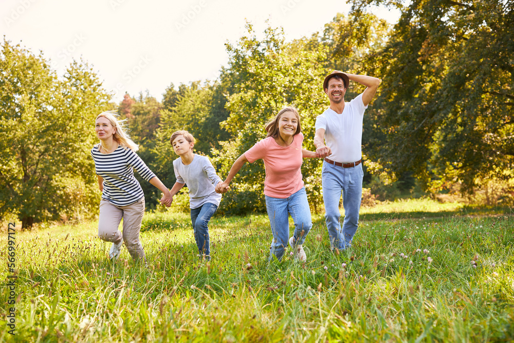 Happy family running hand in hand across meadow Happy family running hand in hand across meadow