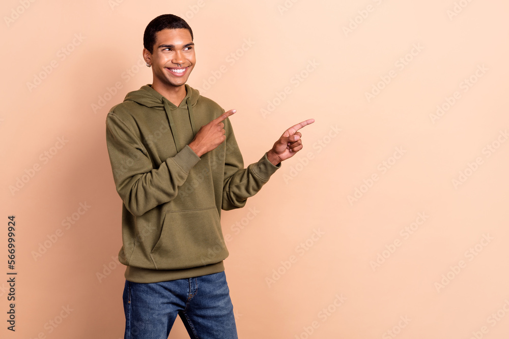 Photo of cheerful young satisfied hipster guy student wear stylish khaki sweatshirt look direct fingers mockup isolated on beige color background Photo of cheerful young satisfied hipster guy student wear stylish khaki sweatshirt look direct fingers mockup isolated on beige color background
