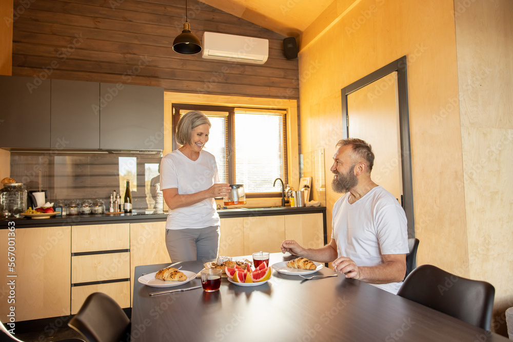 Happy couple having breakfast and feeling comfortable Happy couple having breakfast and feeling comfortable