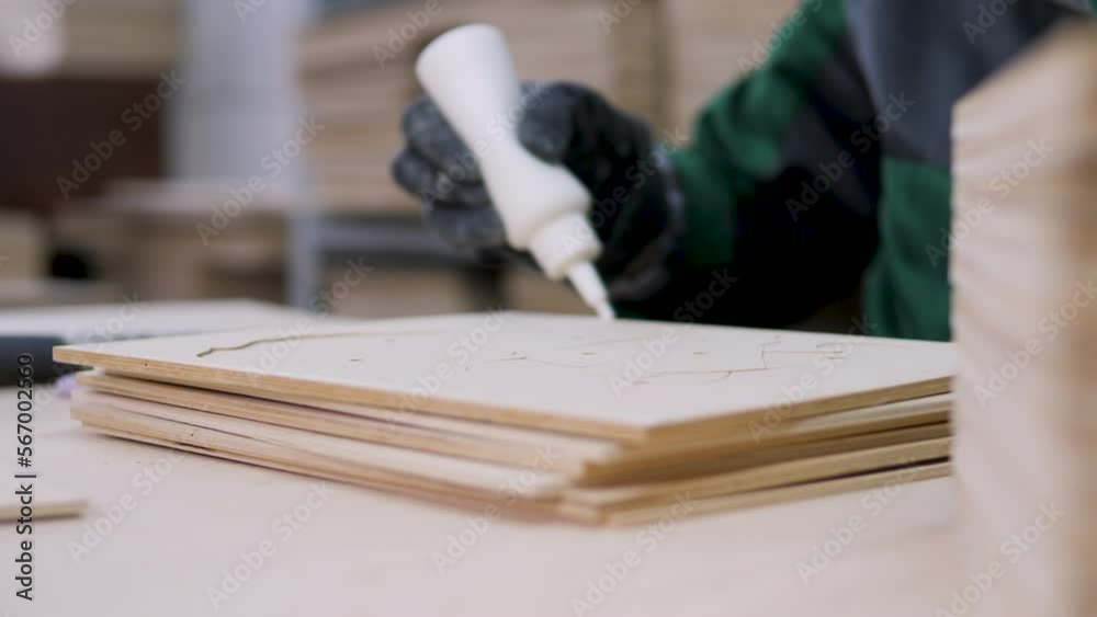 workers glue plywood products with glue. production and processing of wood products. factory. close-up workers glue plywood products with glue. production and processing of wood products. factory. close-up
