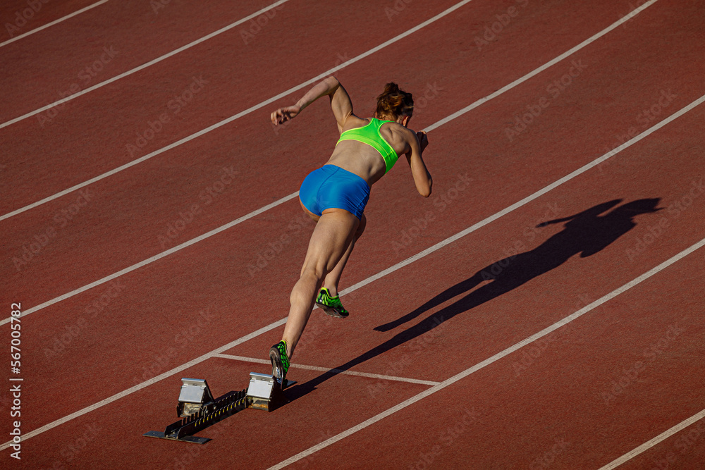 female athlete start running 400 meters in stadium
