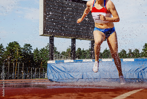 фотографія female athlete running steeplechase in athletics competition