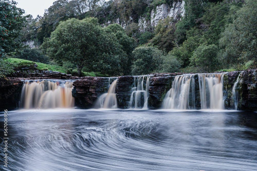 Fototapeta premium Waterfall in the Yorkshire Dales With swirling pools and long exposure to produce blurry out of focus water